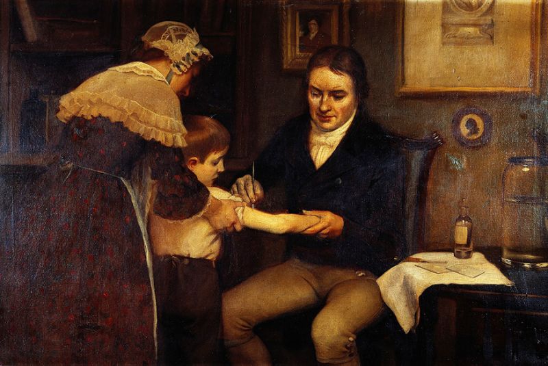 El doctor Jenner realizando sus primeras vacunaciones infantiles en 1796. Oleo de Ernes Board. (Imagen vista en Wikimedia Commons)